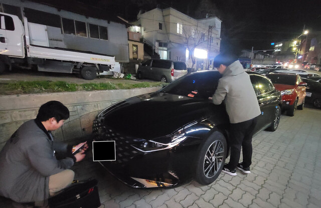 채납자 차량번호판을 영치하기 위해 번호판을 분리하고 있다./울릉군