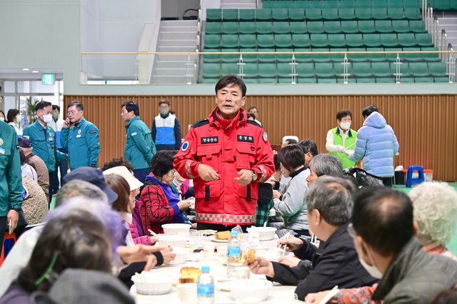 윤경희 청송군수(가운데)가 청송국민체육센터 이재민대피소에서 식사중인 이재민들에게 신속 피해 복구를 약속하고 위로하고 있다. /김종철기자